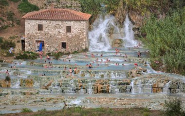 tourists bathing and relaxing at Saturnia hot springs un a late summer day, Toskany, Italy clipart