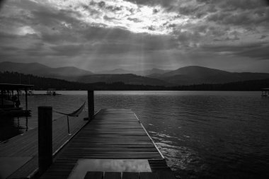 NORDMAN, UNITED STATES - Jul 14, 2020: Sun shining on the dock through the rain clouds in the morning clipart