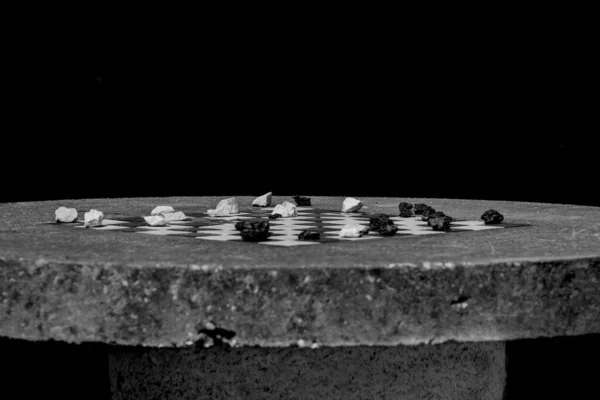 円形のプラットフォーム上のチェスボード上の小さな白と黒の石の閉鎖 — ストック写真