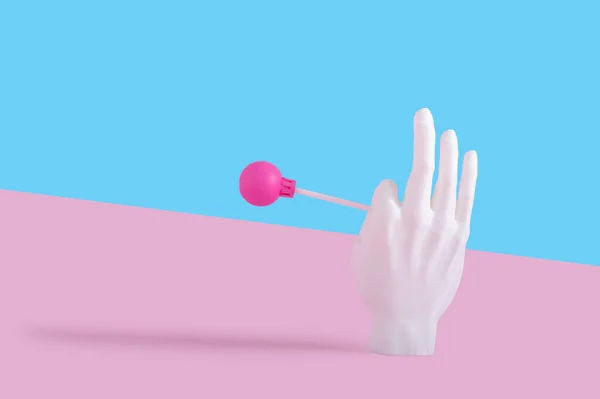 Una Mano Plastica Che Tiene Lecca Lecca Uno Sfondo Rosa — Foto Stock