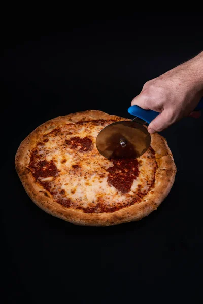 Pionowe Ujęcie Osoby Krojącej Pizzę Domowej Roboty Czarnej Powierzchni — Zdjęcie stockowe