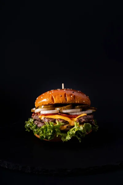 Вертикальный Снимок Вкусного Бургера Черной Поверхности — стоковое фото