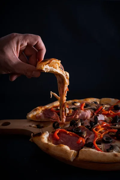 Zbliżenie Osoby Biorącej Kawałek Świeżo Upieczonej Pysznej Pizzy Drewnianej Tacy — Zdjęcie stockowe