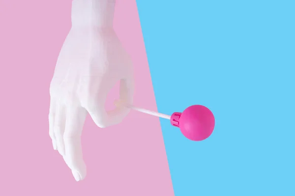 Uma Mão Plástico Segurando Pirulito Fundo Rosa Azul — Fotografia de Stock