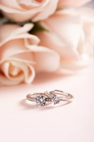 Függőleges Szelektív Fókusz Közelkép Gyémánt Gyűrűk Egy Rózsás Rózsaszín Háttér — Stock Fotó