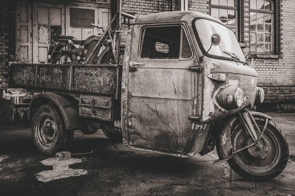 古い道具と自転車を積んだ古いトラックのグレースケールショット — ストック写真