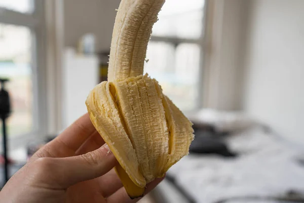 Zbliżenie Osoby Trzymającej Dojrzałego Banana Bez Skórki — Zdjęcie stockowe