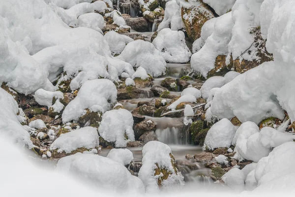 在通往奥地利阿尔丁阿尔卑斯山的路上 山溪流过白雪覆盖的岩石 — 图库照片