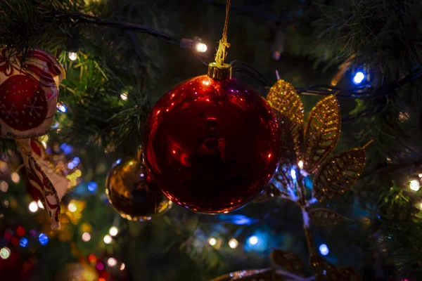 Een Mooie Glimmende Rode Bal Hangend Aan Versierde Kerstboom Weerspiegelend — Stockfoto