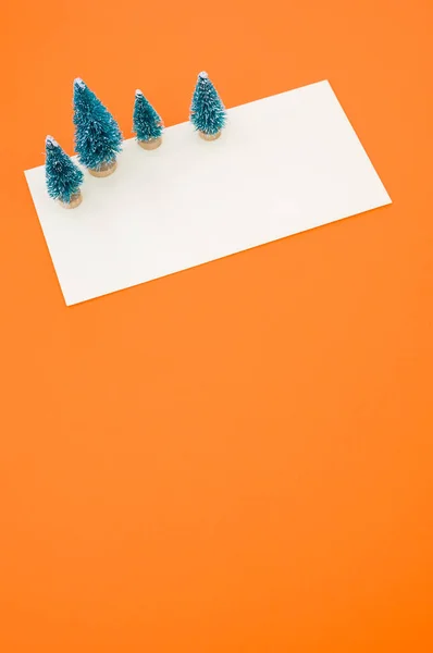 Eine Vertikale Aufnahme Von Weihnachtskiefernfiguren Auf Weißem Und Orangefarbenem Hintergrund — Stockfoto