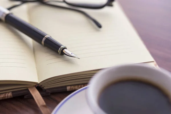 Una Toma Selectiva Una Taza Café Cuaderno Bolígrafo Anteojos —  Fotos de Stock