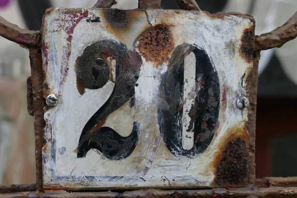 A closeup of an old house number plate number \