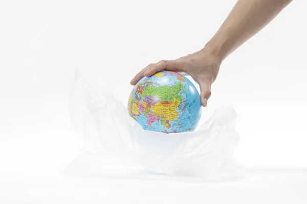 将全球置于塑料袋中的一只手的特写镜头 环保概念 — 图库照片