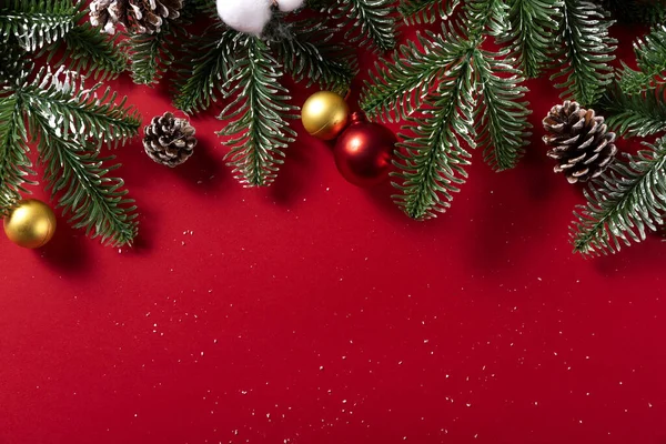 Eine Nahaufnahme Von Künstlichen Fichtenzweigen Mit Weihnachtsschmuck Isoliert Auf Rotem — Stockfoto