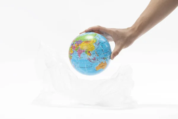 将全球置于塑料袋中的一只手的特写镜头 环保概念 — 图库照片