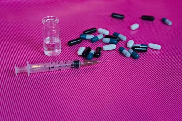 ピンクの背景にアンプルと薬と注射器の針の閉鎖 — ストック写真