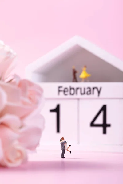 幸せな人形フィギュアカップルと2月14日 バレンタインデーのテーマを示す家の形のカレンダーの選択的フォーカスショット — ストック写真