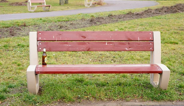 Una Panchina Marrone Legno Con Una Bottiglia Birra Parco — Foto Stock