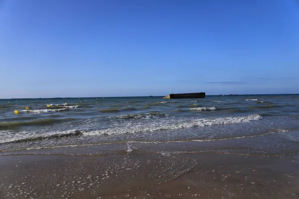砂の海岸を洗う波の選択的な焦点ショット — ストック写真