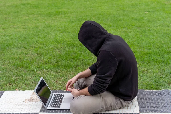 Jovem Sentado Com Uma Postura Usando Seu Laptop Telefone — Fotografia de Stock