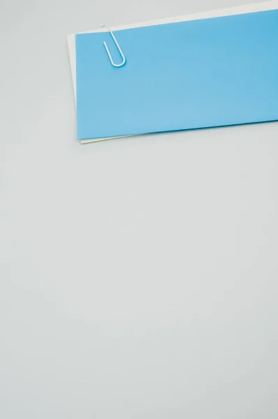 Вертикальный Снимок Листов Бумаги Прикрепленных Скрепкой Сером Фоне — стоковое фото
