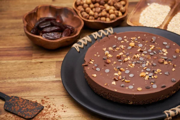 Крупный План Вкусного Шоколадного Пирога Фундуком Пальмовыми Фруктами Тарелке Столе — стоковое фото