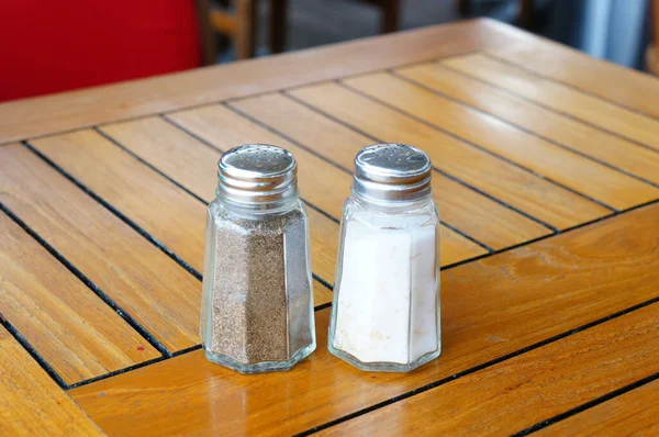 木製のテーブルの上に塩とコショウのクローズアップ — ストック写真