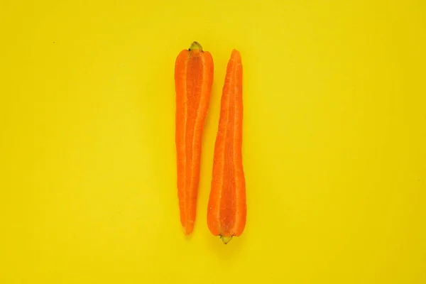 一只胡萝卜在黄色背景上切成两半的特写镜头 健康素食 — 图库照片