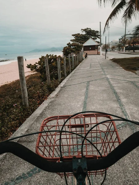 Tiro Vertical Uma Praia Com Uma Bicicleta Primeiro Plano — Fotografia de Stock