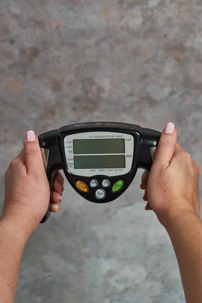 Female Holding Fat Loss Monitor Grunge Background — Stock Photo, Image