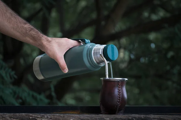 手の選択的フォーカスショットは わらとカラバッシュメイトカップの魔法瓶から水を注ぐ Yerba Mate Tea Inpution — ストック写真