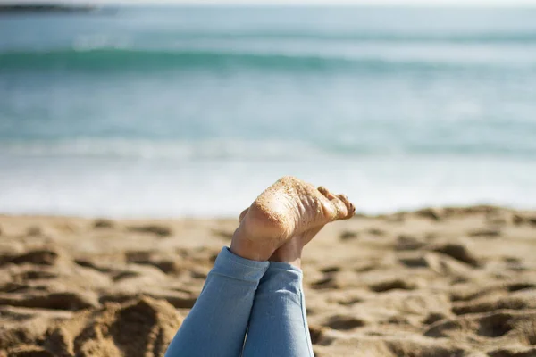 在西班牙巴塞罗那的海滩上 一个穿着牛仔裤 被沙子覆盖的女人的脚在白天被选择性地拍摄的焦点照片 — 图库照片