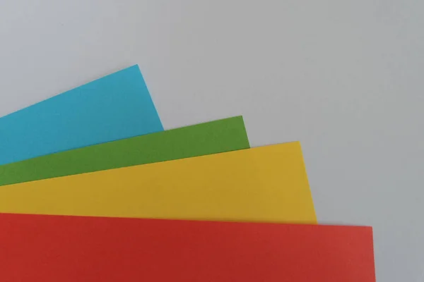 Zbliżenie Ujęcia Kolorowych Papierów Krawędzi Szarej Powierzchni Przestrzenią Kopiującą — Zdjęcie stockowe