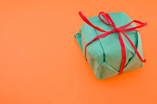 Ένα Πράσινο Κουτί Δώρου Απομονωμένο Πορτοκαλί Φόντο — Φωτογραφία Αρχείου
