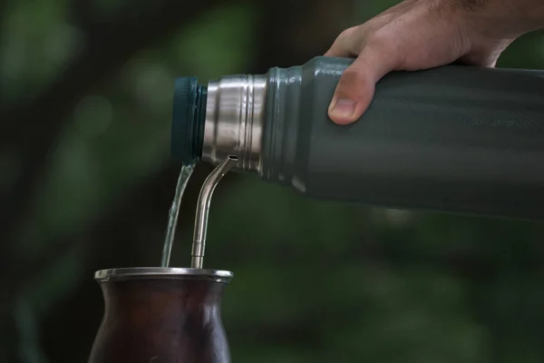 Tiro Enfoque Selectivo Una Mano Que Vierte Agua Termo Una —  Fotos de Stock