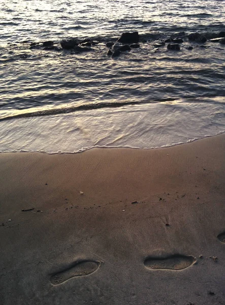 Pionowe Ujęcie Wybrzeża Oceanu Falami Ludzkimi Krokami Piasku — Zdjęcie stockowe
