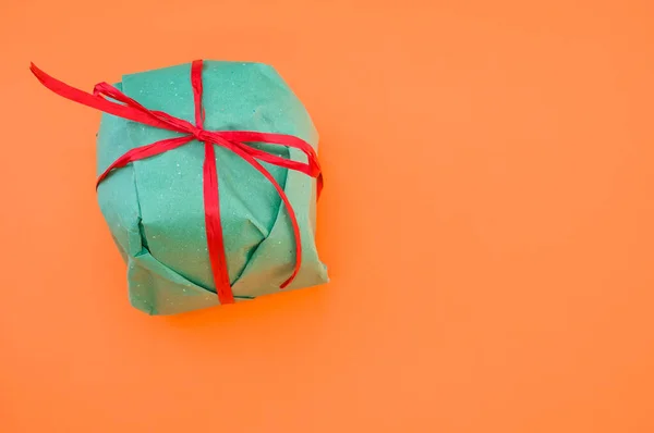 Ένα Πράσινο Κουτί Δώρου Απομονωμένο Πορτοκαλί Φόντο — Φωτογραφία Αρχείου