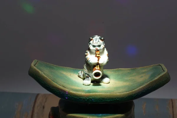 Ένα Κεραμικό Αγαλματάκι Γάτας Που Παίζει Σαξόφωνο Κάτω Από Φώτα — Φωτογραφία Αρχείου