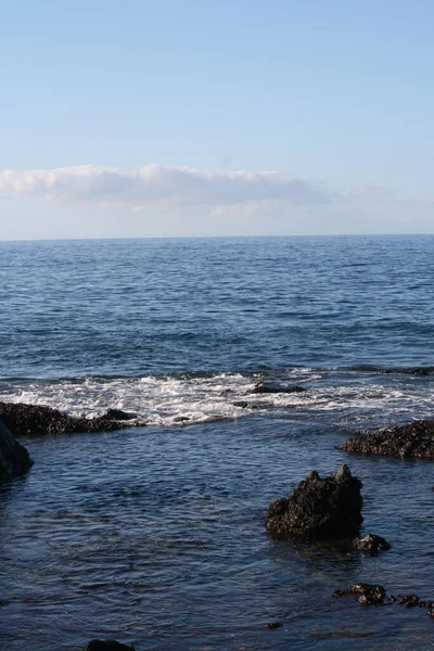 Colpo Verticale Una Costa Rocciosa Dell Oceano Sullo Sfondo Blu — Foto Stock