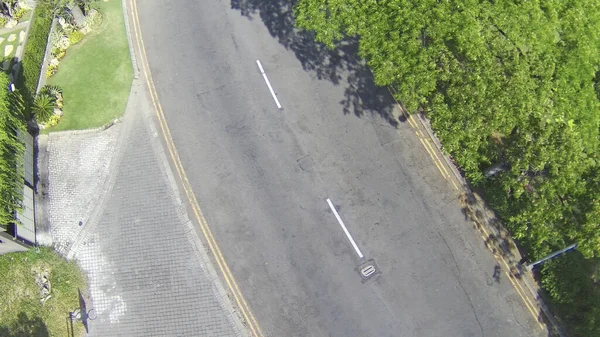 舗装されたアスファルト道路の空中ショットで両側に木があります — ストック写真
