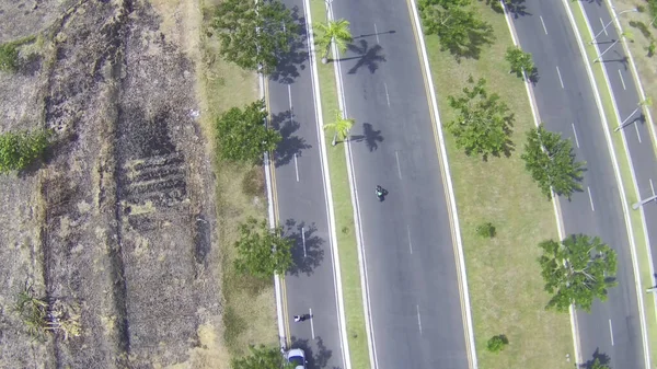 舗装されたアスファルト道路の空中ショットで両側に木があります — ストック写真