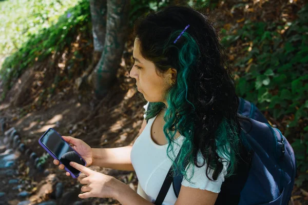 Высокоугольный Снимок Молодой Латиноамериканки Просматривающей Свой Смартфон Стоя Парке — стоковое фото