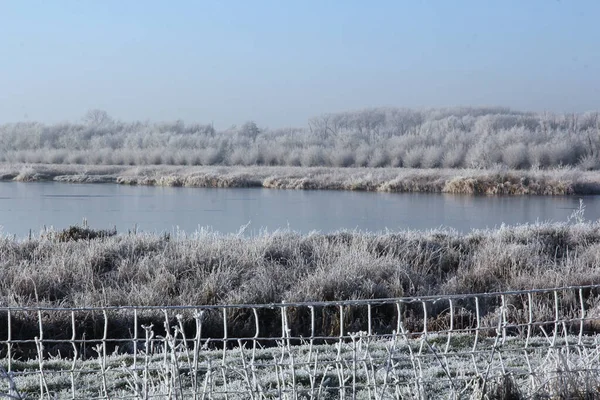 Eine Wunderschöne Winterlandschaft Mit Einem Ruhigen See Und Frostbedeckten Bäumen — Stockfoto