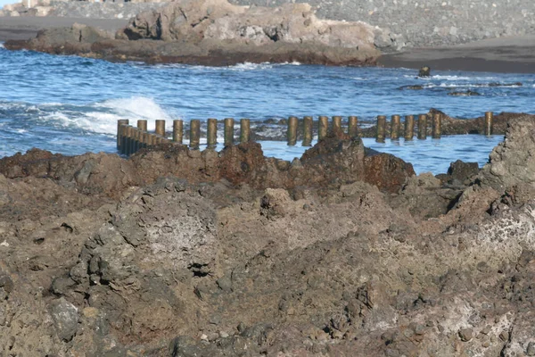 Krásný Záběr Skalnaté Pobřeží Oceánu Dřevěnými Vlnolamy Dne — Stock fotografie