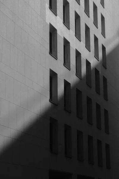 Egy Fekete Fehér Felvétel Egy Modern Épület Homlokzatáról Napfényben — Stock Fotó