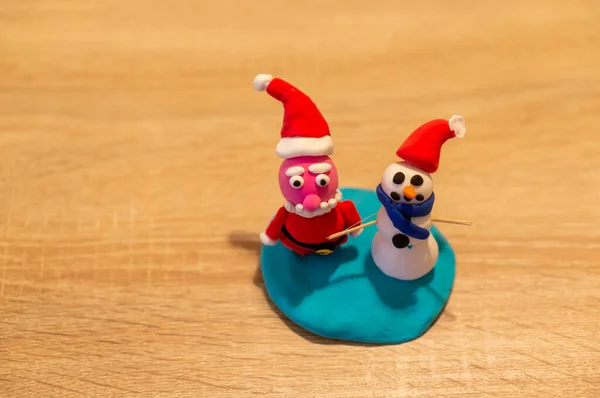 サンタクロースと雪だるまのフィギュアと子供のプラスチッククリスマスクラフトの水平ショット — ストック写真