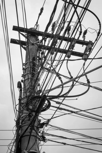 Een Verticale Grijswaarden Opname Van Een Paal Met Veel Elektriciteitsdraden — Stockfoto