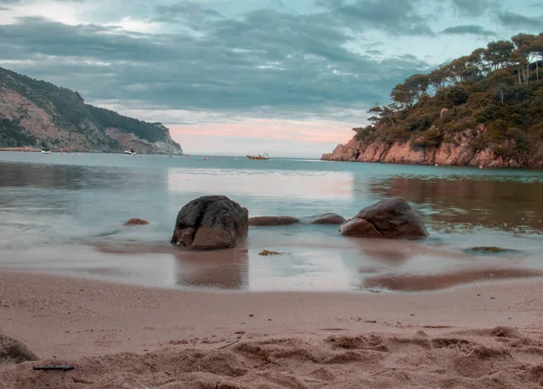 両側に崖がある美しい海を背景にした砂浜 — ストック写真