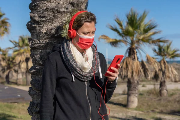 Female Wearing Face Mask Listening Music Using Her Phone — Stock Photo, Image