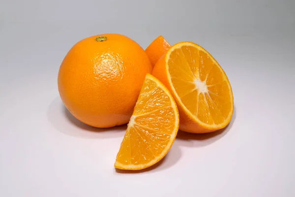 Крупный План Свежего Спелого Апельсина Ломтиками Белой Поверхности — стоковое фото